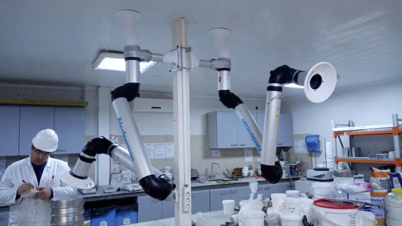 Ceiling-mounted extraction arms over laboratory benches
