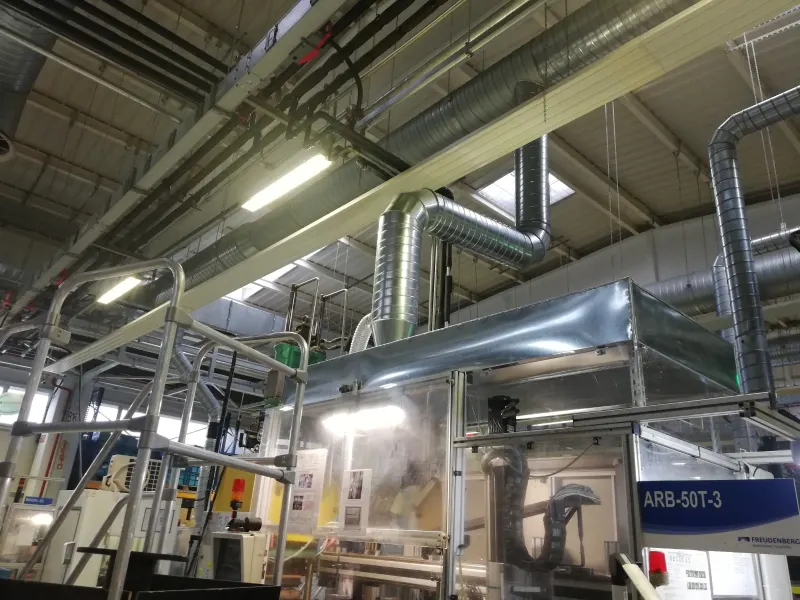 Extraction ducts connected to a machine enclosure